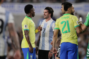 Rodrigo De Paul (c) de Argentina habla con Vinícius Júnior (i) de Brasil durante un partido de las eliminatorias sudamericanas para el Mundial de 2026. EFE/ Luciano González