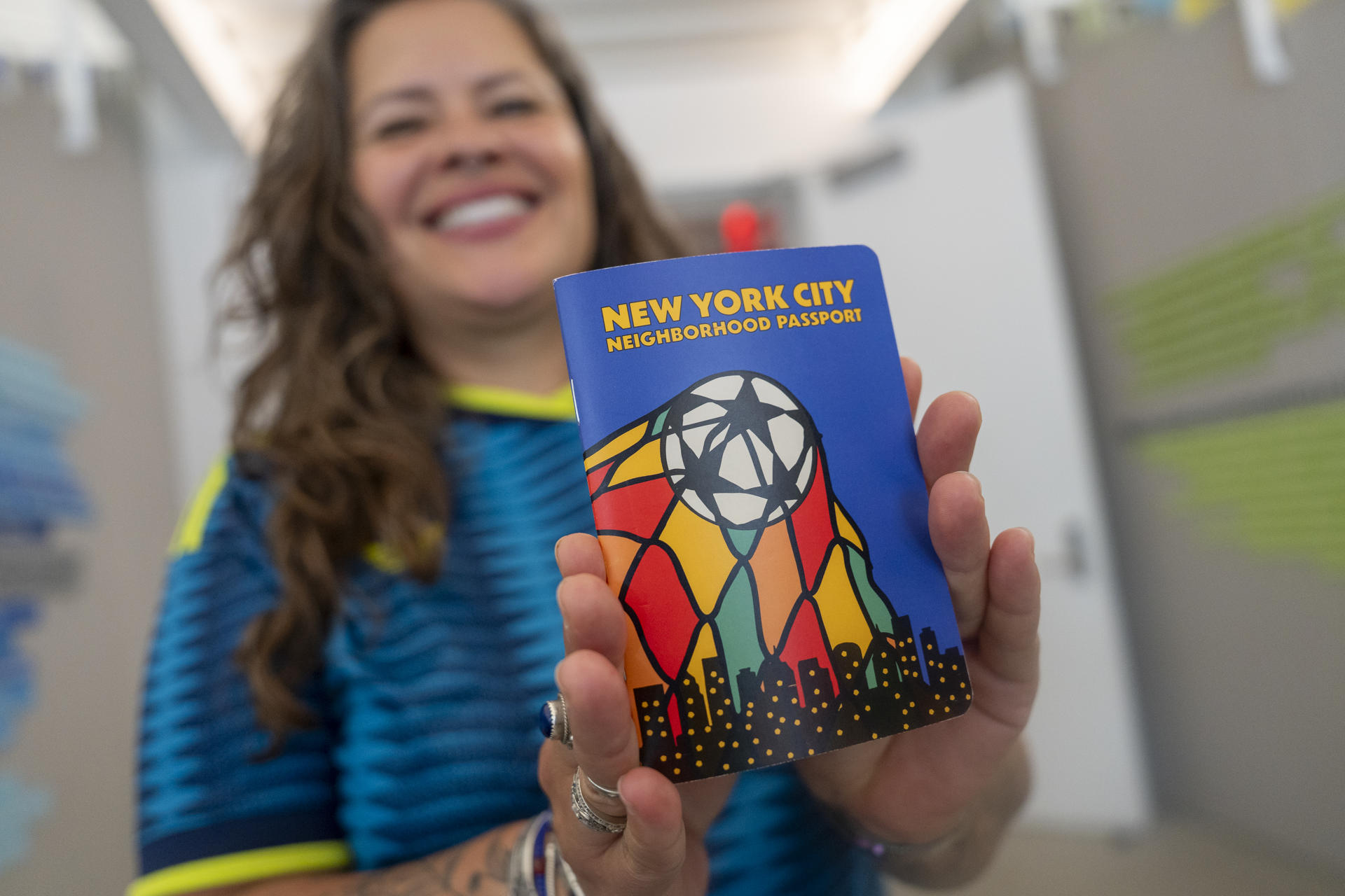 Nathalia Aristizabal de la organización comunitaria Make the Road New York muestra el 'World Cup ‘26 NYC Neighborhood Passport', una iniciativa destinada a acercar a turistas y residentes a los barrios de la ciudad durante la Copa Mundial de Fútbol de 2026, este martes, en Nueva York (Estados Unidos). EFE/ Angel Colmenares