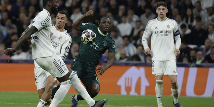 El delantero belga del Manchester City Jeremy Doku (d) disputa el balón ante los jugadores del Real Madrid, el alemán Antonio Rudiger y el británico Trent Alexander-Arnold, durante el encuentro correspondiente a la ida de los octavos de final de la Liga de Campeones que Real Madrid y Manchester City disputaron en el estadio Santiago Bernabéu, en Madrid. EFE/Kiko Huesca