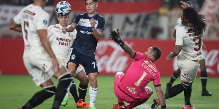 José Carvallo (2-d) de Universitario disputa el balón con Benjamín Domínguez (2-i) de Gimnasia en un partido de fase de grupos de la Copa Sudamericana entre Universitario y Gimnasia y Esgrima en el estadio Monumental en Lima (Perú). EFE/Paolo Aguilar