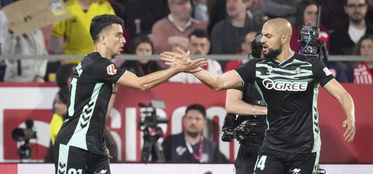 El centrocampista del Betis Marc Roca (i) celebra tras anotar el primer gol del equipo este martes, durante el partido de la jornada 33 de LaLiga EA Sports que disputan el Girona FC y el Real Betis en el Estadio Montilivi. EFE/ David Borrat