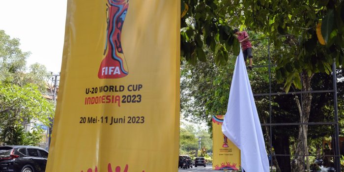 Un trabajador retira una pancarta de la Copa Mundial Sub-20 de la FIFA 2023 en un roan principal en Denpasar, Bali, Indonesia. EFE/EPA/MADE NAGI