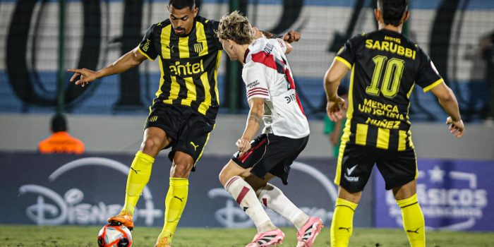 El defensor de River Plate Aníbal Moreno (c) presiona al centrocampista de Peñarol Emanuel Gularte (i) en un partido amistoso de pretemporada jugado este sábado en el estadio Domingo Burgueño Miguel de Maldonado. EFE/ Gaston Britos