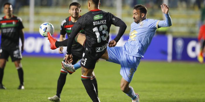 El uruguayo Martín Cauteruccio (d), del Bolívar, disputa un balón con Cristián Suárez, de Palestino, durante un partido del 'playoff' para octavos de final de la Copa Sudamericana en el estadio Hernando Siles en La Paz. EFE/Esteban Biba