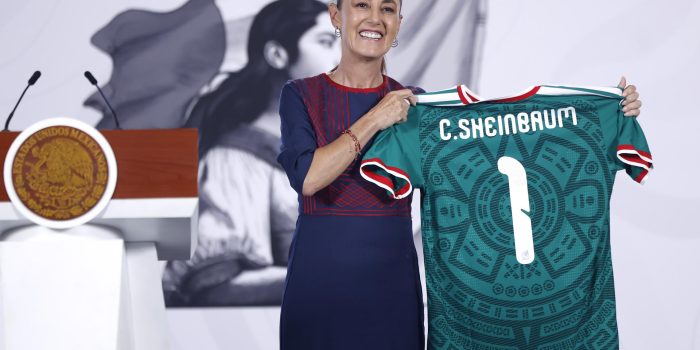 La presidenta de México, Claudia Sheinbaum, posa con una camiseta de la selección de México este lunes, durante una rueda de prensa en el Palacio Nacional de Ciudad de México (México). EFE/ Sáshenka Gutiérrez