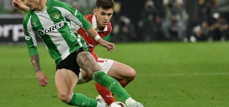 El delantero del Betis Antony dos Santos (i) se escapa de Ricardo Horta, del SC Braga, durante el partido de vuelta de cuartos de final de Liga Europa que disputan Real Betis y SC Braga este jueves en el estadio de La Cartuja, en Sevilla. EFE/Raúl Caro.