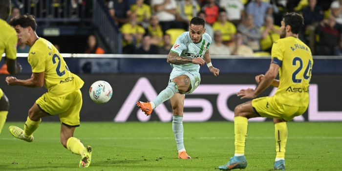 El delantero brasileño del Betis Antony (c) dispara para anotar un tanto durante el encuentro correspondiente a la novena jornada de LaLiga EA Sports que disputaron Villarreal y Betis en el estadio de La Cerámica, en la localidad castellonense. EFE / Andreu Esteban