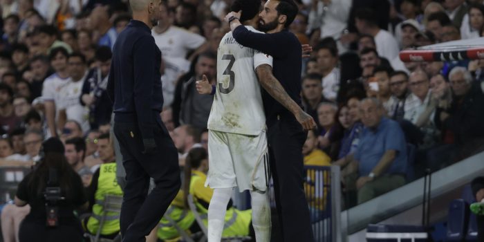 El defensa del Real Madrid Éder Militão (c) es consolado por el técnico Álvaro Arberloa tras abandonar el terreno de juego durante el partido contra el Alavés. EFE/ Juanjo Martín