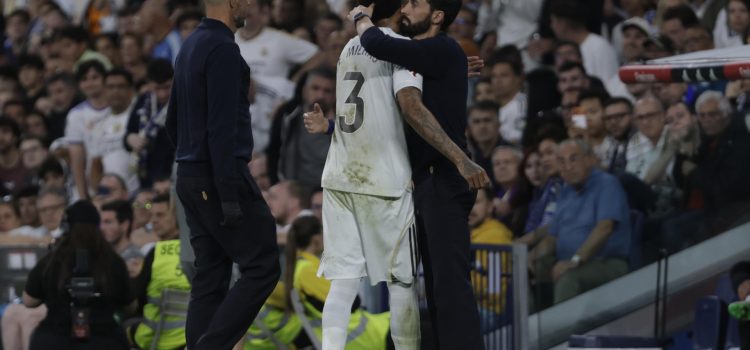 El defensa del Real Madrid Éder Militão (c) es consolado por el técnico Álvaro Arberloa tras abandonar el terreno de juego durante el partido contra el Alavés. EFE/ Juanjo Martín