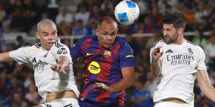 Giovanni Silva (c), del equipo de las leyendas del Barcelona disputa un balón con Pepe (i), de las leyendas de Real Madrid, en el estadio Olímpico Félix Sánchez en Santo Domingo (República Dominicana). EFE/Orlando Barría