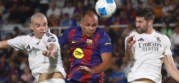 Giovanni Silva (c), del equipo de las leyendas del Barcelona disputa un balón con Pepe (i), de las leyendas de Real Madrid, en el estadio Olímpico Félix Sánchez en Santo Domingo (República Dominicana). EFE/Orlando Barría
