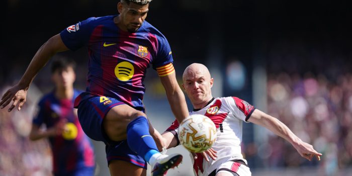 El jugador del FC Barcelona Ronald Araujo (i) lucha por el balón con Isi (d), del Rayo Vallecano, durante su partido de la jornada 29 de LaLiga EA Sports en el Camp Nou, este domingo. EFE/ Alejandro Garcia