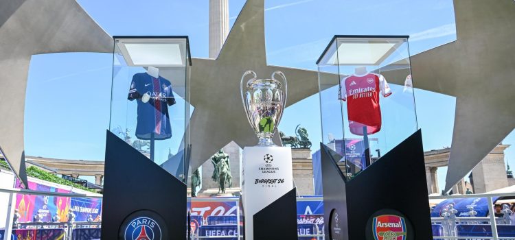 El trofeo de la Liga de Campeones expuesto entre las camisetas del Arsenal y del Paris Saint-Germain en la Fan Zone en Budapest este jueves. EFE/EPA/Tibor Illyes HUNGARY OUT