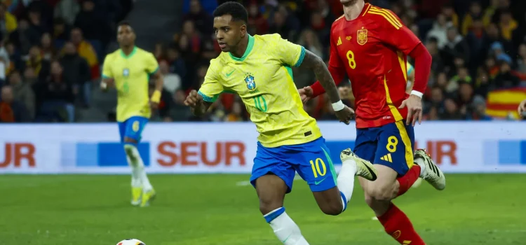 El delantero de la selección brasileña Rodrygo Goes (i) se escapa de Fabián Ruiz, de la selección española, durante el partido amistoso que las selecciones nacionales de fútbol de España y Brasil disputan hoy martes en el estadio Santiago Bernabéu, en Madrid. EFE/Mariscal