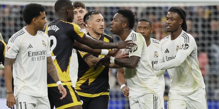 El delantero del Real Madrid Vinícius Jr (c) y los defensas del Rayo Vallecano Andrei Rațiu (3i) y Nobel Mendy (2i) durante el partido de LaLiga que enfrentó al Real Madrid y al Rayo Vallecano, este domingo, en el Santiago Bernabéu. EFE/ Ballesteros
