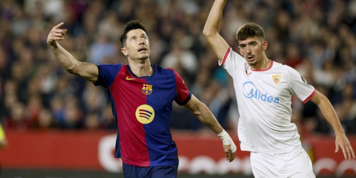 El delantero del FC Barcelona Robert Lewandowski (i) junto al sevillista Kike Salas, durante el encuentro de la jornada 23 de la pasada LaLiga EA Sports disputado en el Sánchez Pizjuán. EFE/ Julio Muñoz