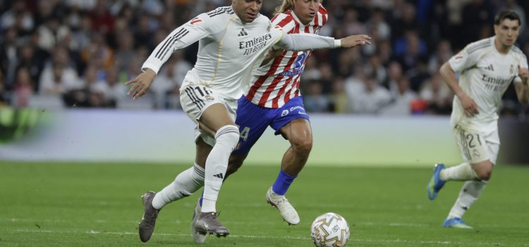 El delantero del Real Madrid Kylian Mbappé (i) escapa de Marcos Llorente, del Atlético, durante el partido de la jornada 29 de LaLiga que Real Madrid y Atlético de Madrid disputaron este domingo en el estadio Santiago Bernabéu. EFE/Juanjo Martín