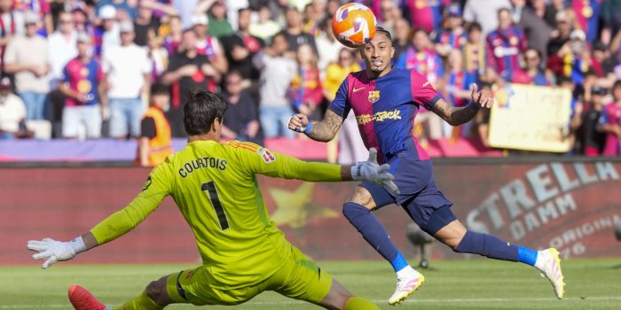 El delantero del Barcelona Raphinha, y el portero del Real Madrid Thibaut Courtois, durante el partido de la jornada 35 de LaLiga EA Sports entre el Barcelona y el Real Madrid, este domingo en el Estadi Olímpic Lluís Companys.-EFE/ Siu Wu