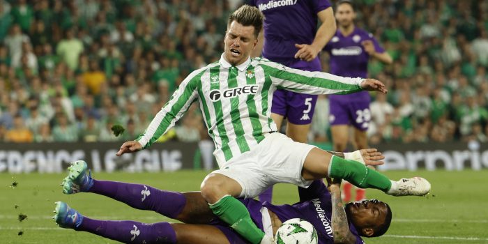 El centrocampista argentino del Betis, Giovani Lo Celso, cae ante el defensor de la Fiorentina durante el partido de ida de las semifinales de la Liga Conferencia en Sevilla. EFE/Julio Muñoz