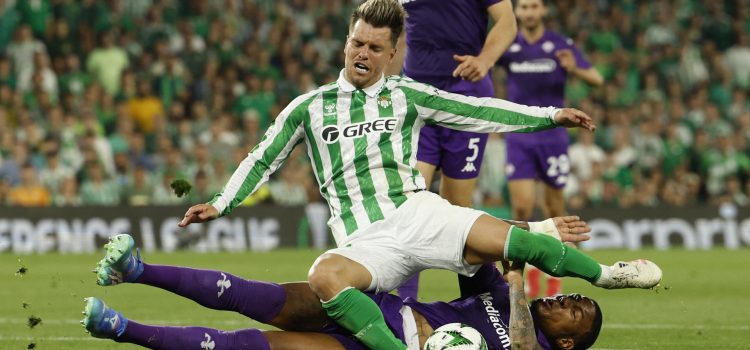 El centrocampista argentino del Betis, Giovani Lo Celso, cae ante el defensor de la Fiorentina durante el partido de ida de las semifinales de la Liga Conferencia en Sevilla. EFE/Julio Muñoz