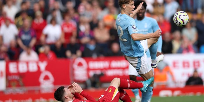 El jugador del Liverpool Andrew Robertson cae al césped ante un jugador del Nottingham Forest durante el partido de la Premier League jugado en Anfield. EFE/EPA/ADAM VAUGHAN