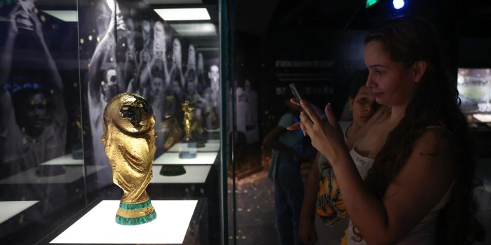 Una mujer toma una fotografía a una réplica de la Copa Mundo de la FIFA este viernes en el Museo Conmebol en Luque (Paraguay). EFE/ Juan Pablo Pino