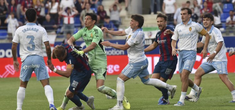 El argentino Esteban Andrada (3i), portero del Zaragoza, da un puñetazo al capitán del Huesca Jorge Pulido (2i) tras ser expulsado en el tiempo añadido del partido entre ambos equipos disputado ayer en la jornada 37 de LaLiga Hypermotion. EFE/Veronica Lacasa