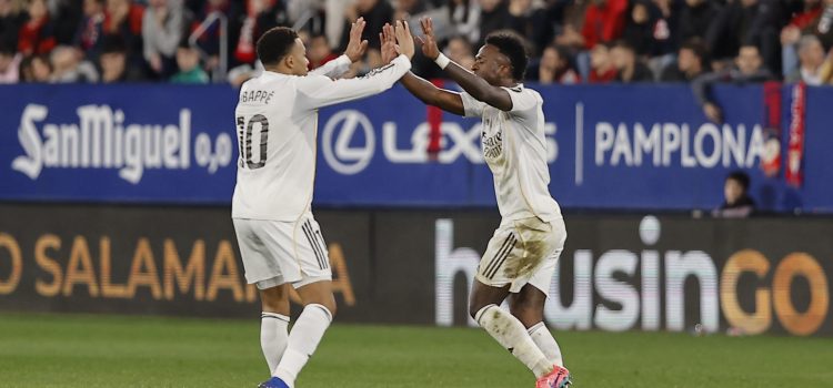 El delantero brasileño del Real Madrid Vinícius Júnior (d) celebra con su compañero, el francés Kylian Mbappé, tras anotar el gol del empate durante el partido de la jornada 25 de LaLiga que disputaron CA Osasuna y Real Madrid en el estadio de El Sadar de Pamplona. EFE/ Villar López