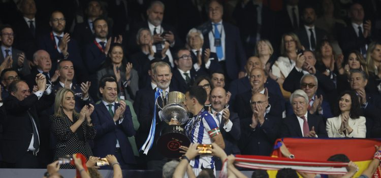 El capitán de la Real Sociedad Mikel Oyarzabal (c) recibe el trofeo de manos de su majestad el Rey tras la final de la Copa del Rey que han disputado frente al Atlético de Madrid este sábado en el estadio de La Cartuja, en Sevilla. EFE/Julio Muñoz.