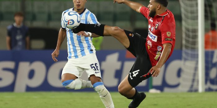 El defensor de Caracas Jesús Quintero (d) se exige al máximo para ganar un balón dividido al extremo de Racing Club Tomás Agustín Pérez este miércoles, durante el partido de la tercera jornada de la fase de grupos de la Copa Sudamericana jugado en el estadio Olímpico de la Universidad Central de Venezuela. EFE/ Miguel Gutiérrez
