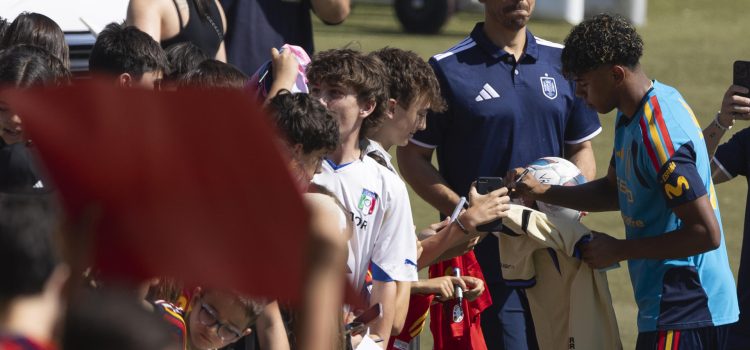 El delantero de la selección española de fútbol Lamine Yamal firma autógrafos antes del entrenamiento en la Ciudad del Fútbol en Las Rozas. EFE/Sergio Pérez