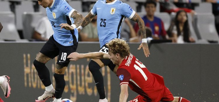 El delantero uruguayo Brian Rodríguez (i), fue registrado este sábado, 13 de julio, al intentar superar la marca del centrocampista canadiense Jacob Shaffelburg (d), durante el partido por el tercer puesto en la Copa América 2024, en el estadio Bank of America de Charlotte (Carolina del Norte, EE.UU.). EFE/Erik S. Lesser