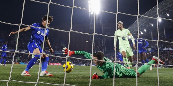 El guardameta del FC Barcelona, Iñaki Peña (d), intenta detener el balón rematado por el centrocampista uruguayo del Getafe, Mauro Arambarri, en la jugada que ha significado el primer gol del equipo madrileño durante el encuentro correspondiente a la jornada 20 de Laliga EA Sports que disputaron Getafe y FC Barcelona en el Coliseum de Getafe. EFE / Chema Moya..