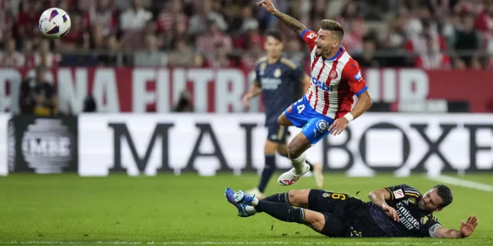 El centrocampista del Girona Cristian Portugués "Portu" (encima) pelea un balón con el defensa del Real Madrid Nacho Fernández durante el partido de la jornada 8 de Liga de Primera división entre el Girona y el Real Madrid. EFE/Siu Wu