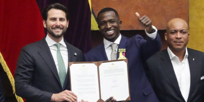 El futbolista Willian Pacho (c) posa junto al presidente de la Asamblea Nacional de Ecuador, Niels Olsen (i), luego de recibir una condecoración por ser el primer ecuatoriano en ganar la Liga de Campeones. EFE/José Jácome