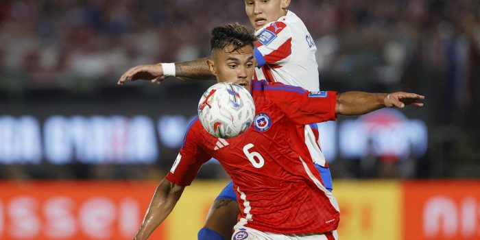 Juan José Cáceres (atrás) de Paraguay disputa un balón con Vicente Pizarro de Chile en un partido de las eliminatorias sudamericanas para el Mundial de 2026. EFE/ Juan Pablo Pino