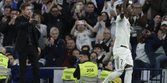 El delantero del Real Madrid Vinicius Junior (d) abandona el terreno de juega ante el técnico Diego Simeone, del Atlético, durante el partido de la jornada 29 de LaLiga que Real Madrid y Atlético de Madrid han disputado este domingo en el estadio Santiago Bernabéu. EFE/Juanjo Martín
