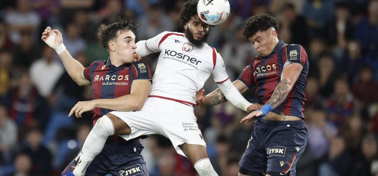 El defensa francés de Osasuna, Valentín Rosier (c), intenta despejar el balón ante el defensa uruguayo del Levante, Alan Matturro (d), en la jugada que ha significado el tercer gol del equipo levantinista durante el partido correspondiente a la jornada 35 de LaLiga EA que han disputado este viernes Levante UD y el CA Osasuna en el estadio Ciudad de Valencia. EFE/ Kai Forsterling