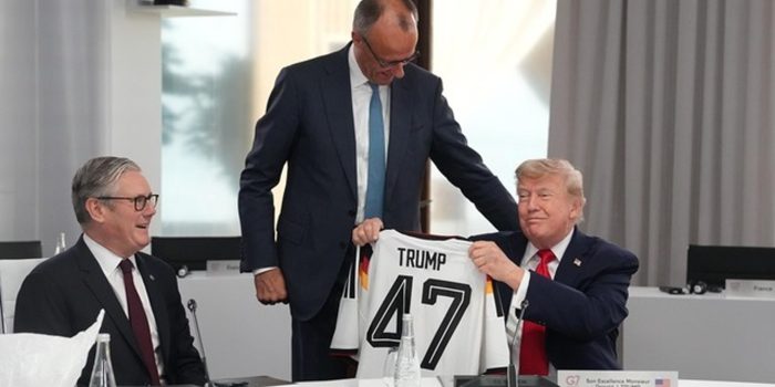 El presidente de Estados Unidos, Donald Trump (d), sostiene una camiseta de Alemania con su apellido y el número 47, junto al primer ministro británico, Keir Starmer (i), y el canciller alemán, Friedrich Merz (de pie), durante la cumbre del G7. EFE/ THIBAULT CAMUS / POOL *Prohibido su uso por MAXPPP*