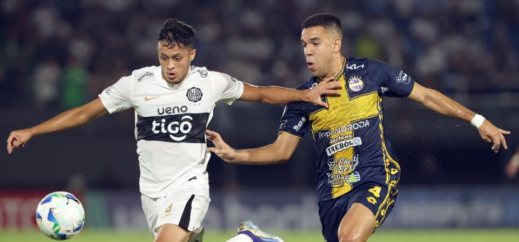Alex Franco (i), de Olimpia, avanza ante la marca de Diego Melgarejo, de Sportivo Trinidense. EFE/Juan Pablo Pino