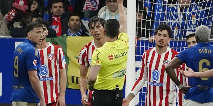 El colegiado muestra tarjeta amarilla al defensa del Atlético de Madrid Robin Le Normand durante el partido de LaLiga de fútbol que Real Oviedo y Atlético de Madrid disputaron en el estadio Carlos Tartiere. EFE/Paco Paredes