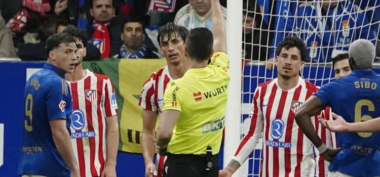 El colegiado muestra tarjeta amarilla al defensa del Atlético de Madrid Robin Le Normand durante el partido de LaLiga de fútbol que Real Oviedo y Atlético de Madrid disputaron en el estadio Carlos Tartiere. EFE/Paco Paredes