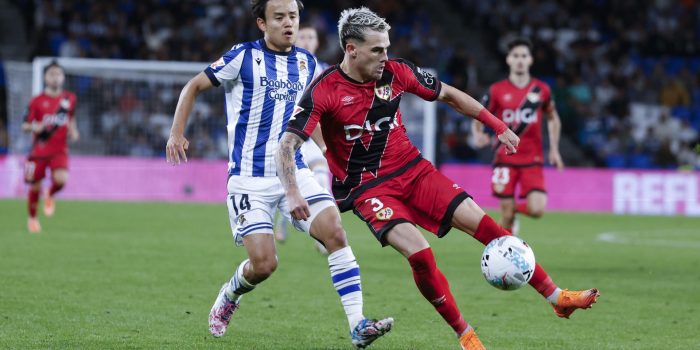 El lateral del Rayo Pep Chavarría (d) juega un balón ante Take Kubo, de la Real. EFE/Jaun Herrero