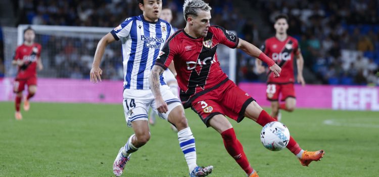 El lateral del Rayo Pep Chavarría (d) juega un balón ante Take Kubo, de la Real. EFE/Jaun Herrero